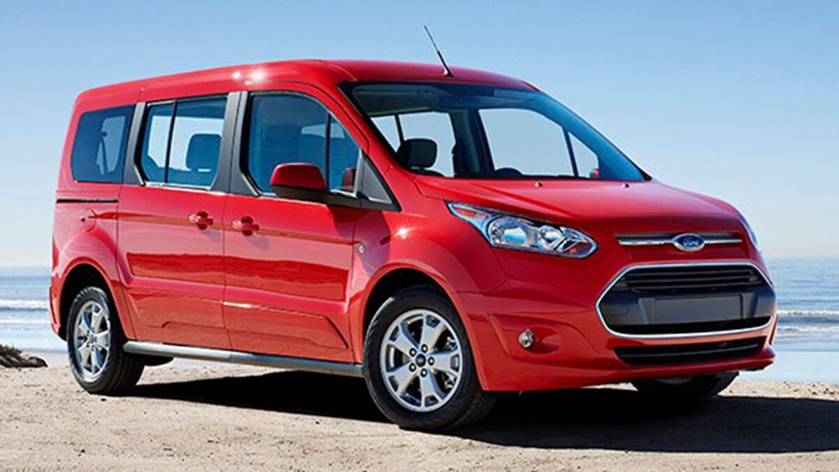 2015 Ford Transit Connect in  red parked by the beach.