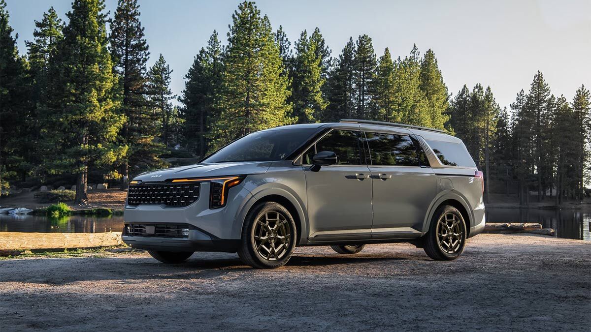 2025 Kia Carnival parked in the forest.