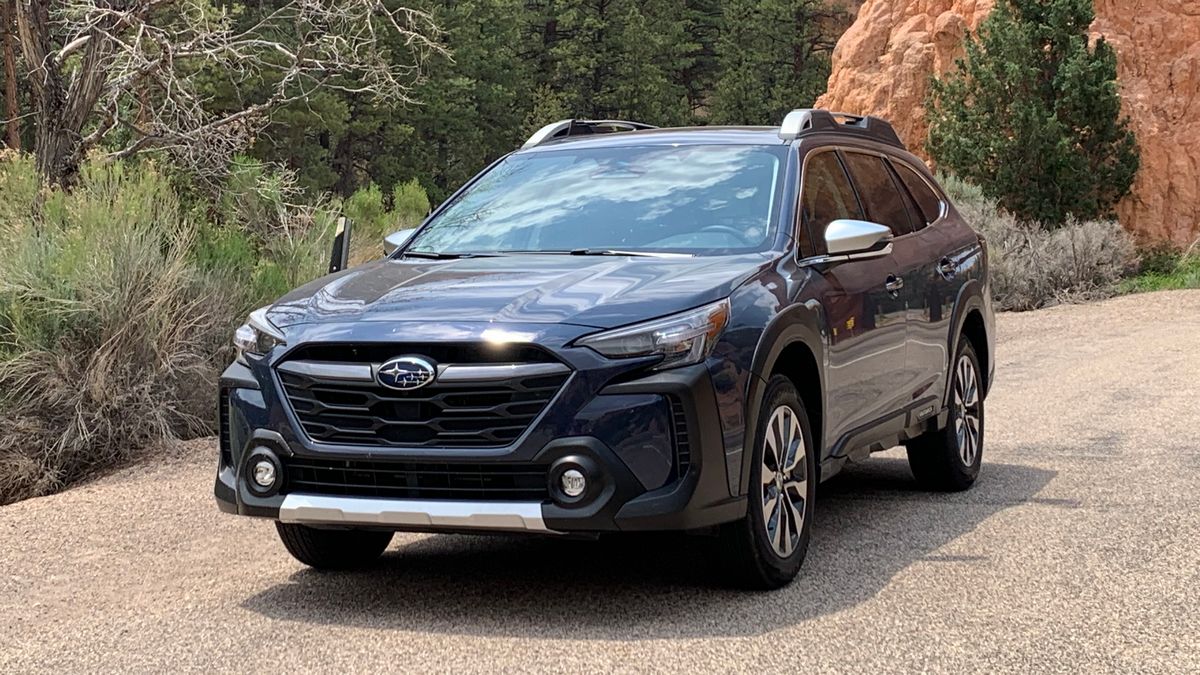 2025 Subaru Outback parked by greenery.
